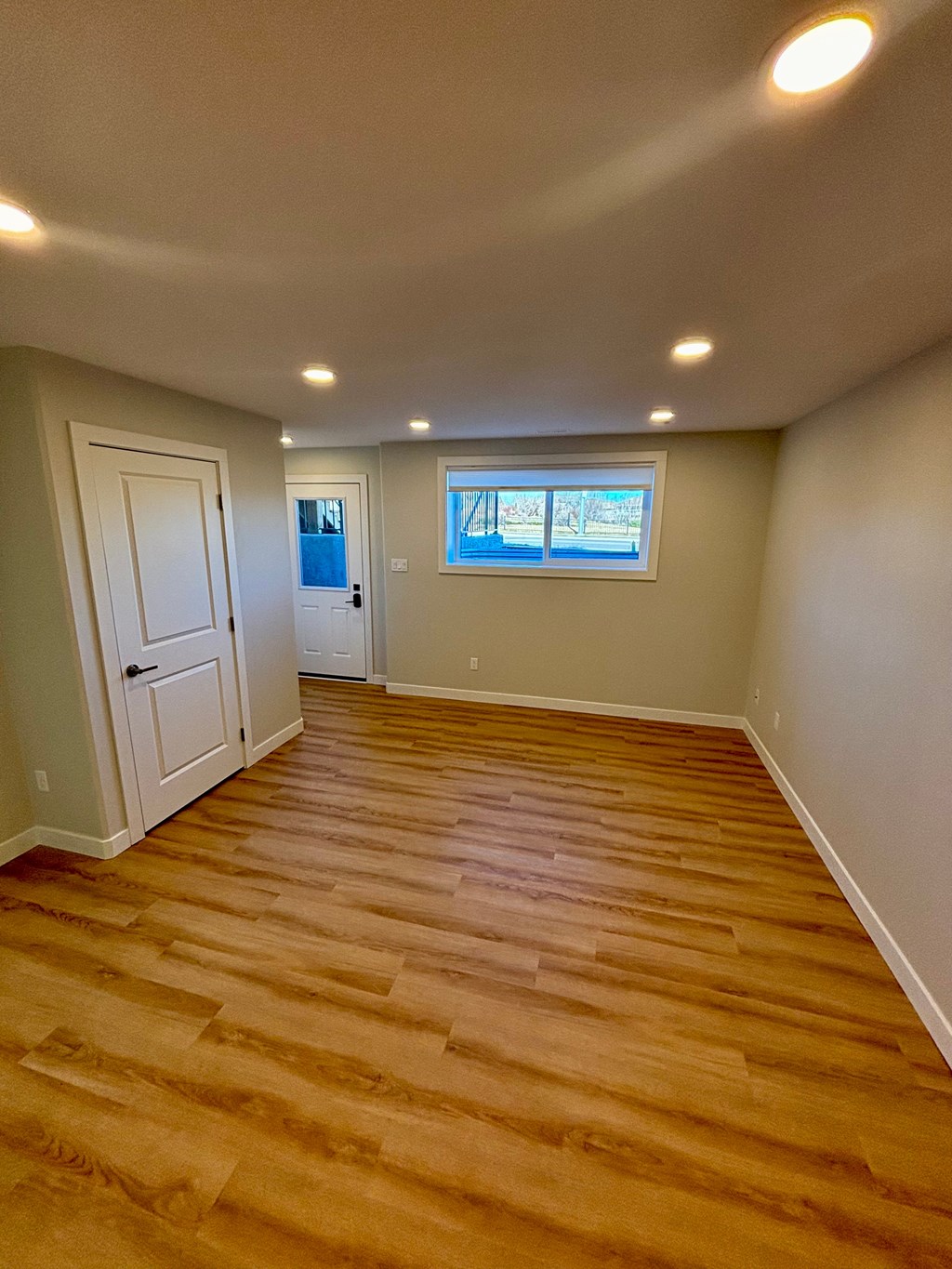 A room with wooden flooring and a window.