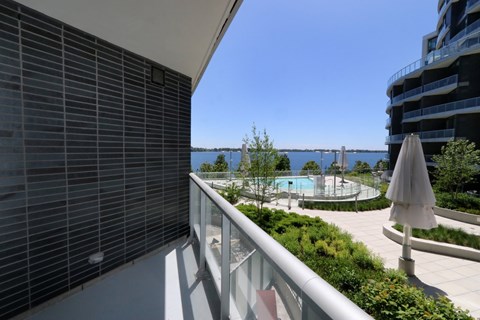 A balcony with a pool and a view of the water.