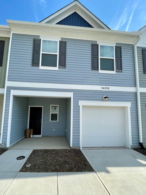 A two-story house with a garage and a white door.