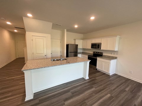 A kitchen with a granite countertop and white cabinets.