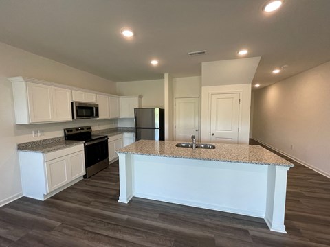 A kitchen with a granite countertop and white cabinets.