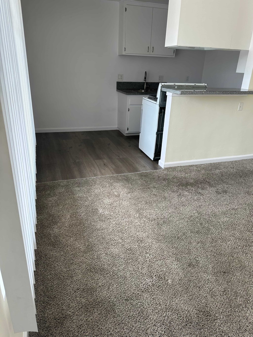 A kitchen with white cabinets and a white dishwasher.