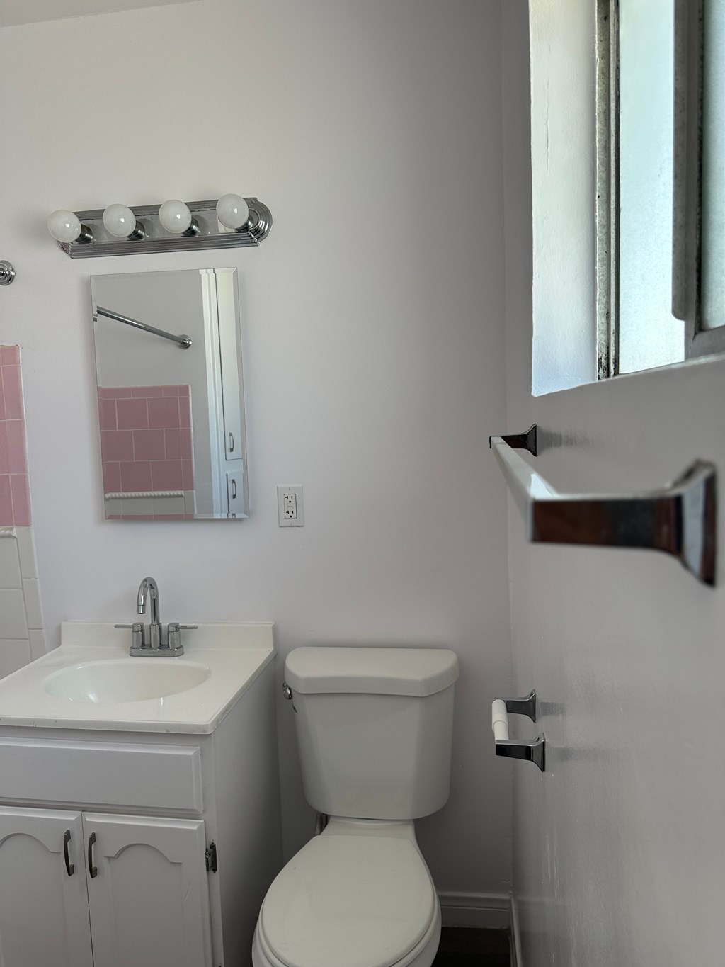 A white toilet sits next to a sink in a bathroom.