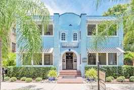 A blue building with a black gate in front.