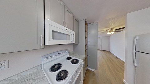 A white stove and microwave in a kitchen with white cabinets.