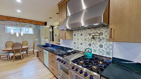 A kitchen with a stove top oven and a tile backsplash.