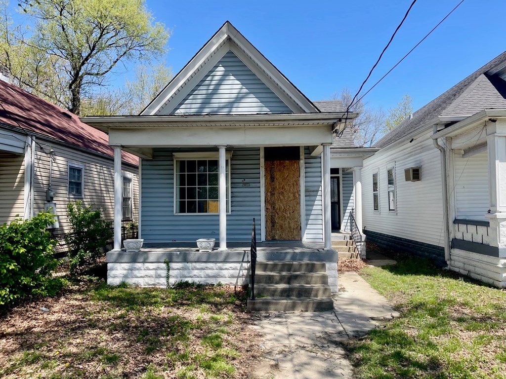 A blue house with a brown door and a grey roof.