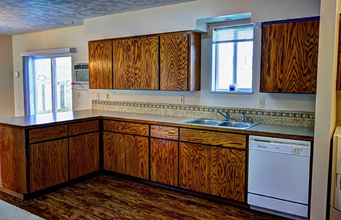 A kitchen with wooden cabinets and a washing machine.