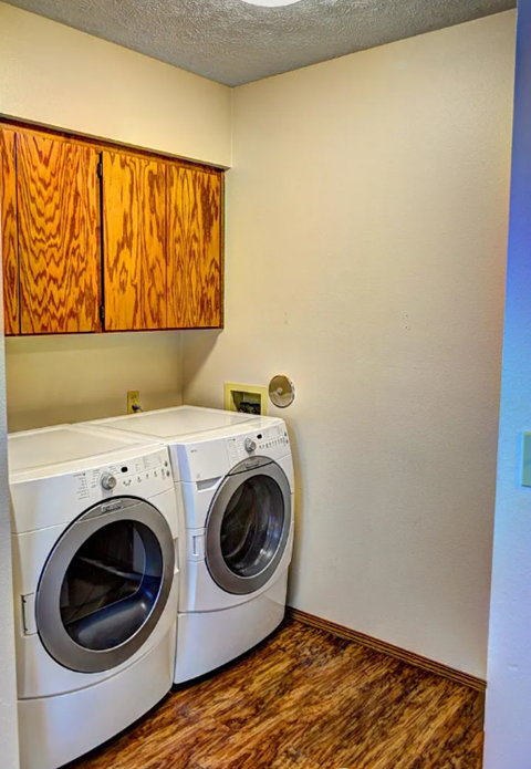 Two washing machines in a small laundry room.