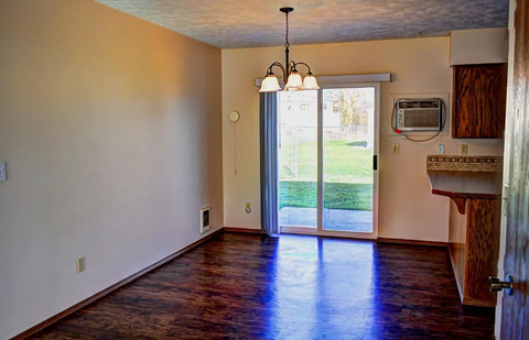A room with a wooden floor and a chandelier.