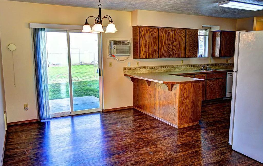 A kitchen with wooden cabinets and a white refrigerator.