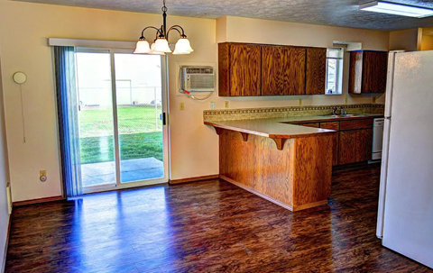 A kitchen with wooden cabinets and a white refrigerator.