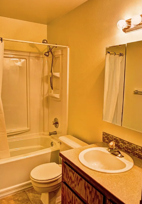 A bathroom with a toilet, sink, and bathtub.