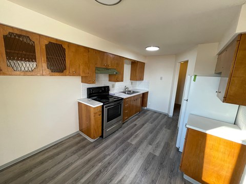 A kitchen with a white fridge and wooden cabinets.
