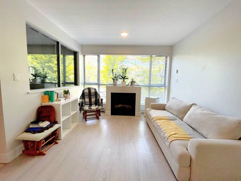 A living room with a fireplace, couch, and a chair.