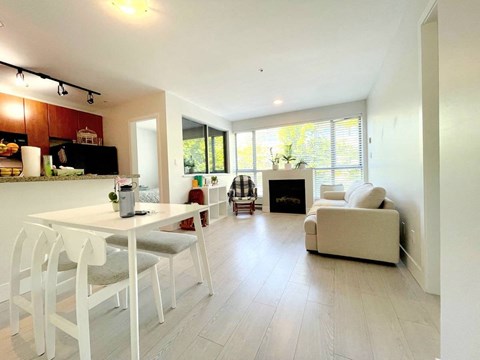 A modern kitchen with white chairs and a dining table.