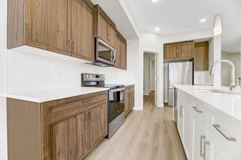A kitchen with wooden cabinets and white countertops.