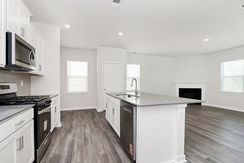 A kitchen with white cabinets and a black stove top oven.