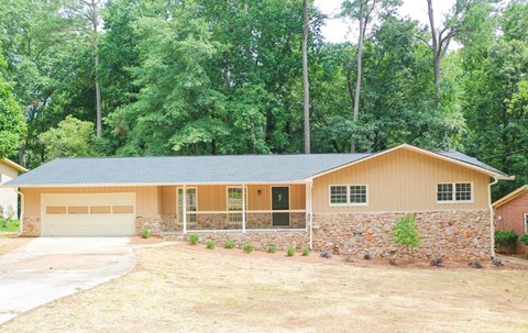 A house with a garage and a stone wall.