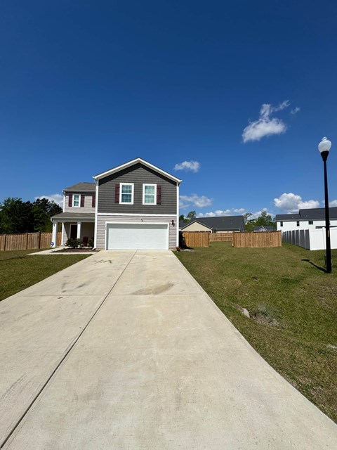 A house with a grey roof and a white garage door.