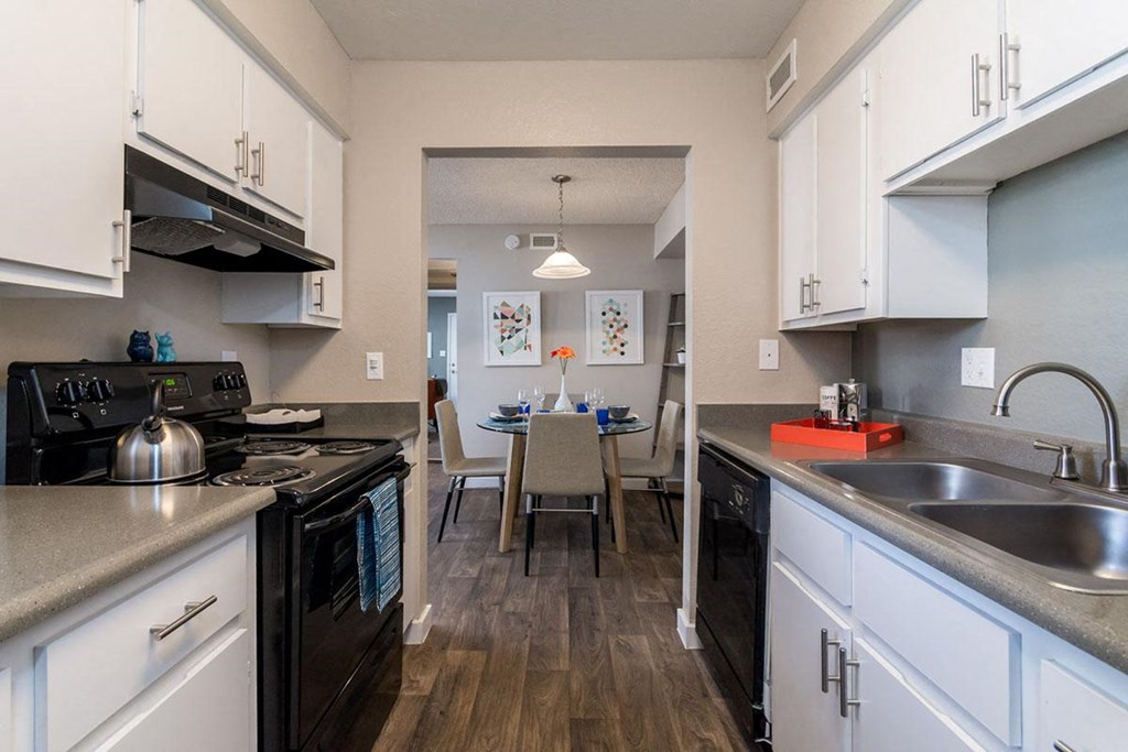 A kitchen with black appliances and white cabinets.