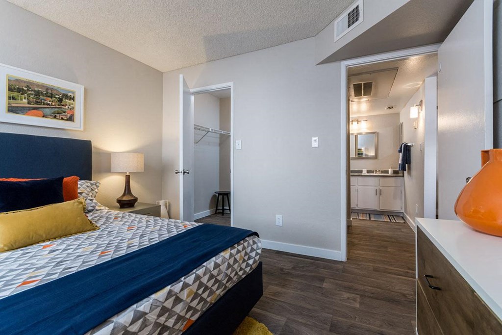 A bedroom with a bed, a lamp, and a picture on the wall.