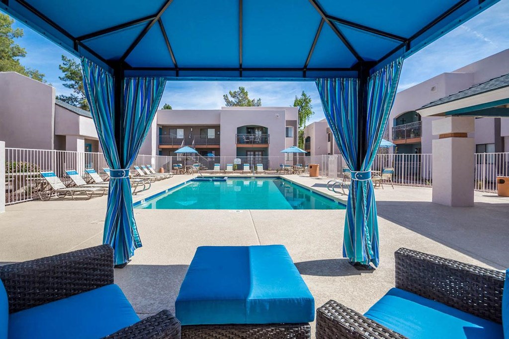 A pool area with blue furniture and a blue canopy.
