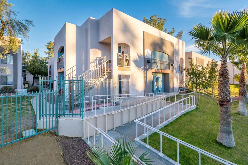 A modern building with a white exterior and a blue gate.