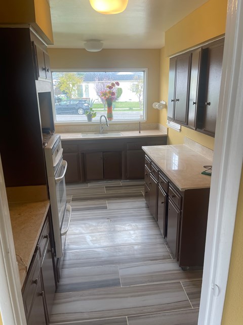 A kitchen with a black refrigerator and wooden cabinets.