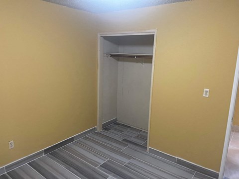 A room with a yellow wall and a grey floor.