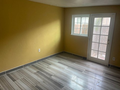 A room with a wooden floor and a white door.
