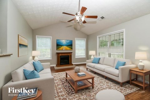 A living room with a couch, a coffee table, and a painting on the wall.