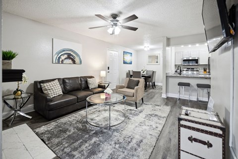 A living room with a couch, chairs, and a coffee table.