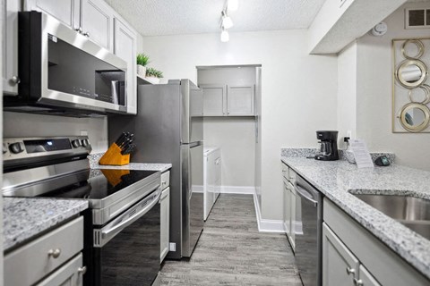 A kitchen with a refrigerator, stove, and microwave.