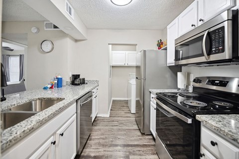 A kitchen with a stove top oven and a microwave above it.