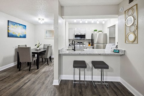 A kitchen with a dining table and chairs.