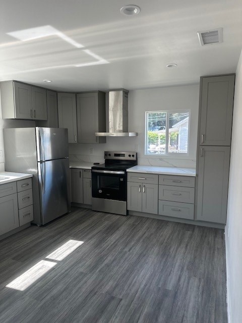 A modern kitchen with a stainless steel refrigerator, oven, and cabinets.