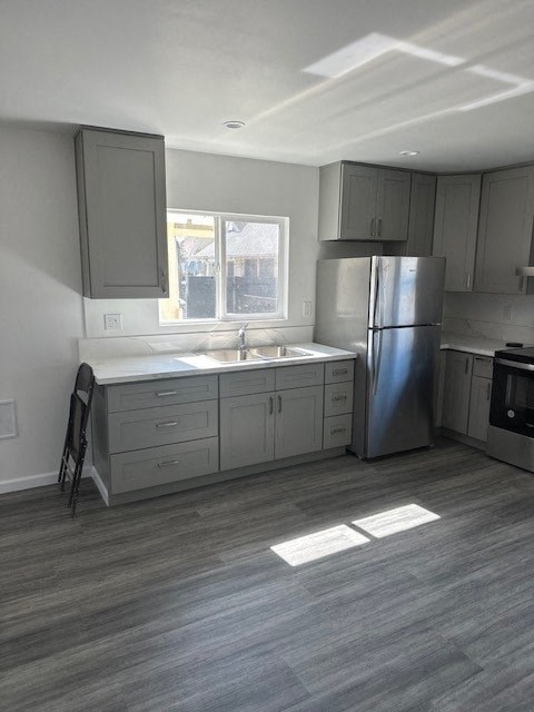 A kitchen with a sink, refrigerator, and cabinets.