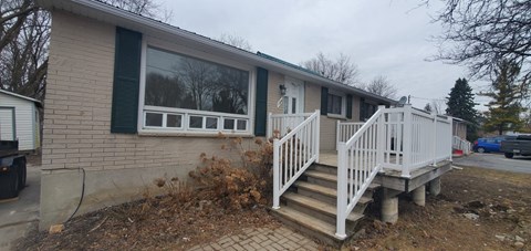 A house with a white porch and green shutters.