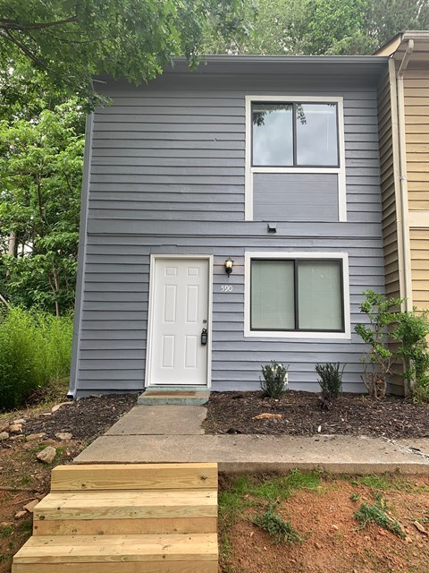 A grey house with a white door and windows.