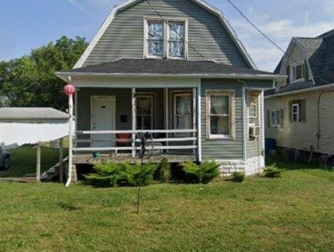 A small house with a porch and a white awning.