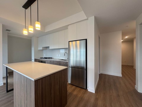 A kitchen with a wooden island and stainless steel appliances.