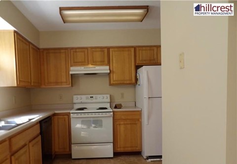 A kitchen with wooden cabinets and white appliances.