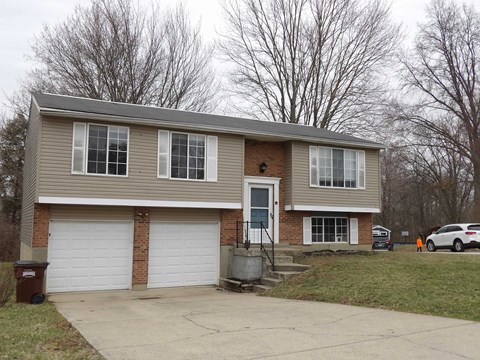 A two-story house with a garage and a driveway.