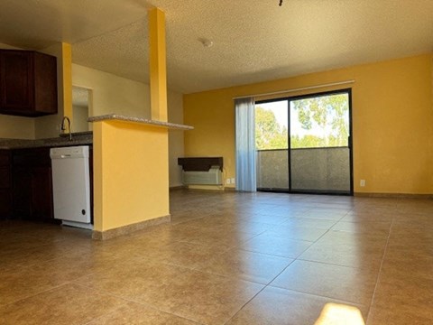 A yellow kitchen with a white dishwasher and a black fridge.