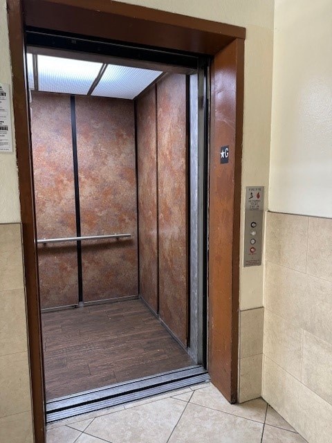 A brown elevator with a silver handle and buttons.