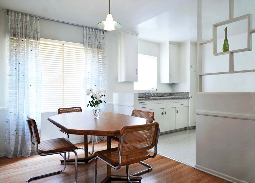 A dining room with a wooden table and chairs.