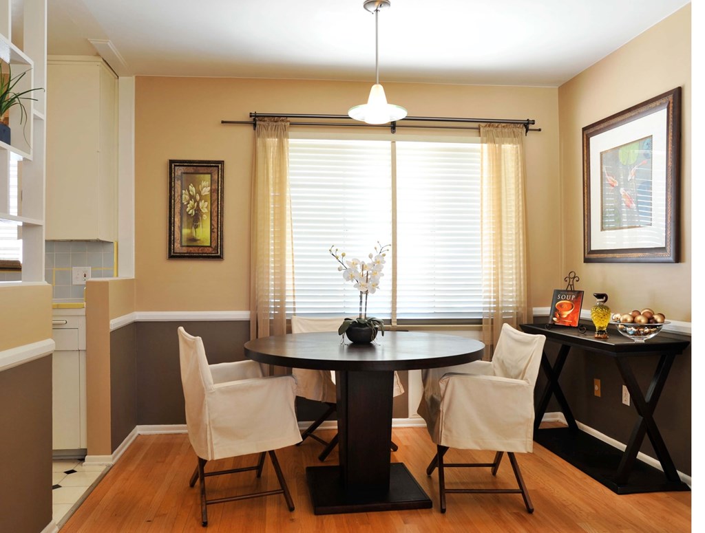 A dining room with a table and chairs.