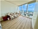 A living room with a couch and a view of the ocean.