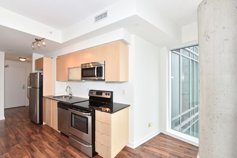 A kitchen with wooden cabinets and stainless steel appliances.